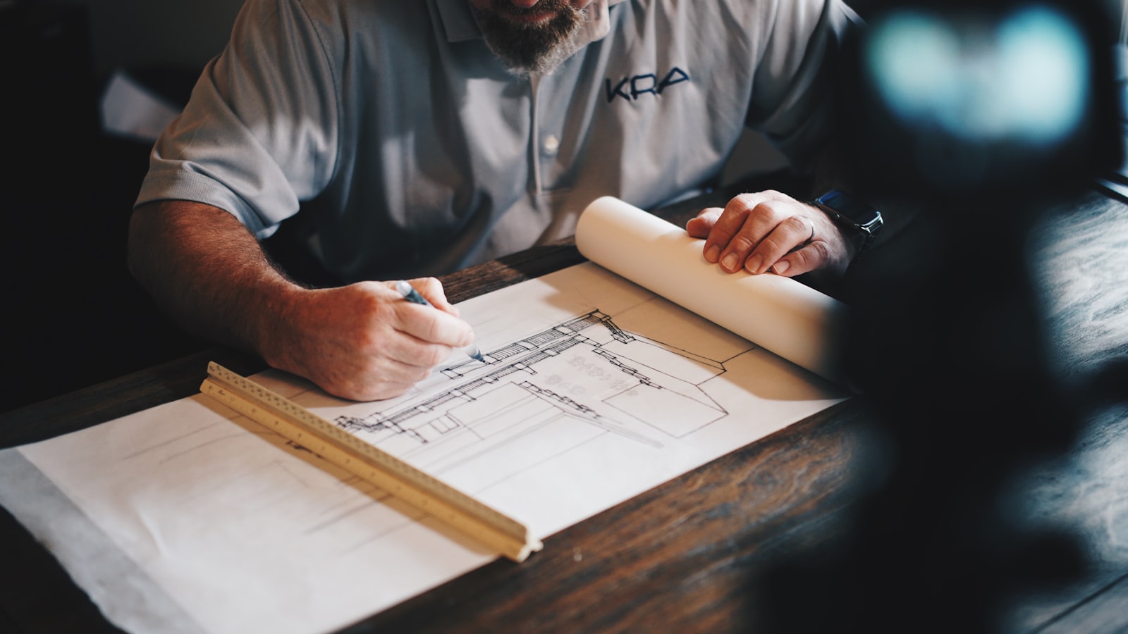 Architect reviewing a hand-drawn floor plan blueprint
