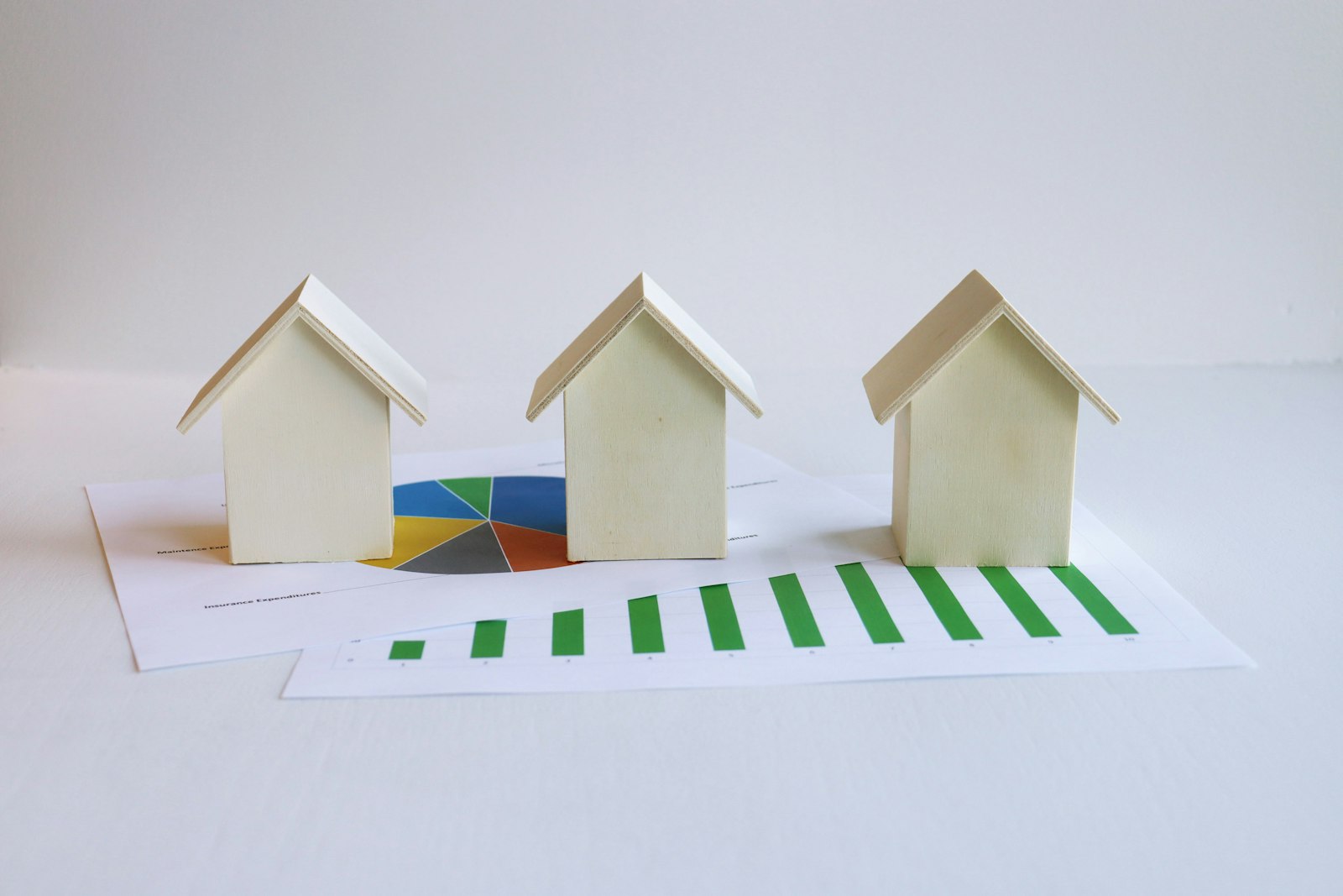 Model wooden houses on top of investment charts and graphs